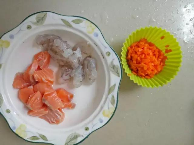 第2步：三文鱼切块，滴入几滴柠檬汁腌制，虾剥壳去虾线，胡萝卜切丁。