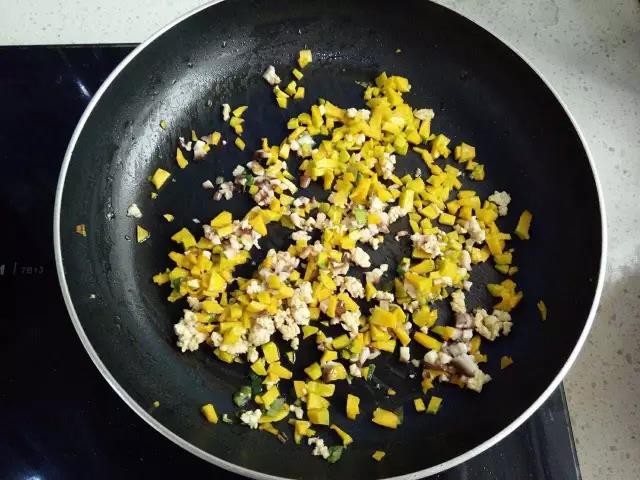 锅里加少许油，加葱花炒香，下肉末炒散，加入南瓜丁和香菇末翻炒均匀。