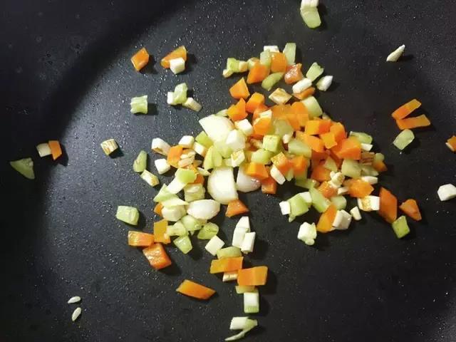 锅内倒入大蒜炒香后再下锅翻炒蔬菜丁。