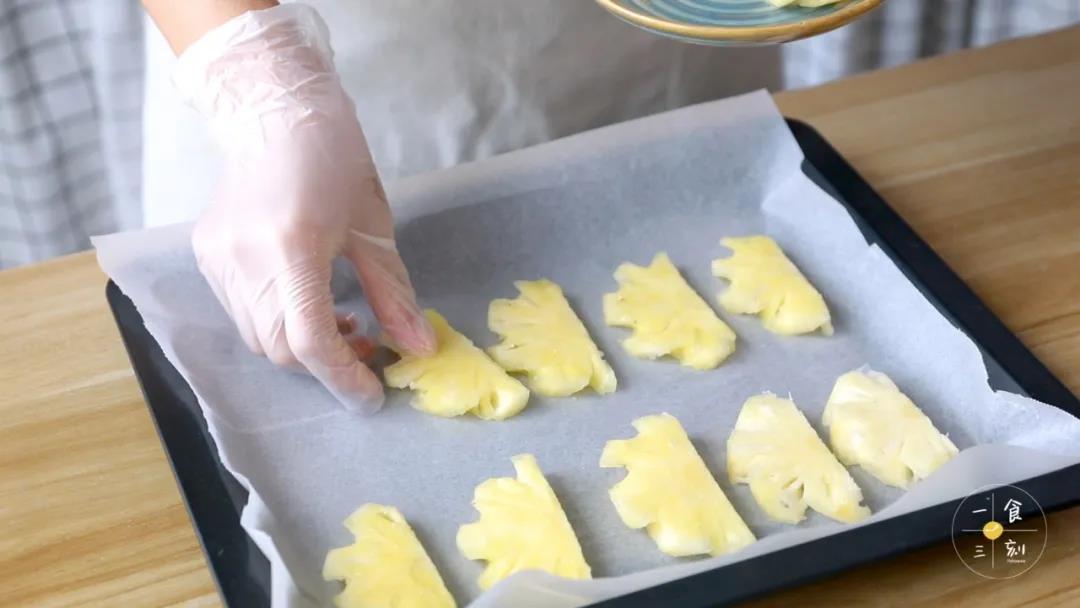 烤盘上垫上油纸，放入菠萝片摆好