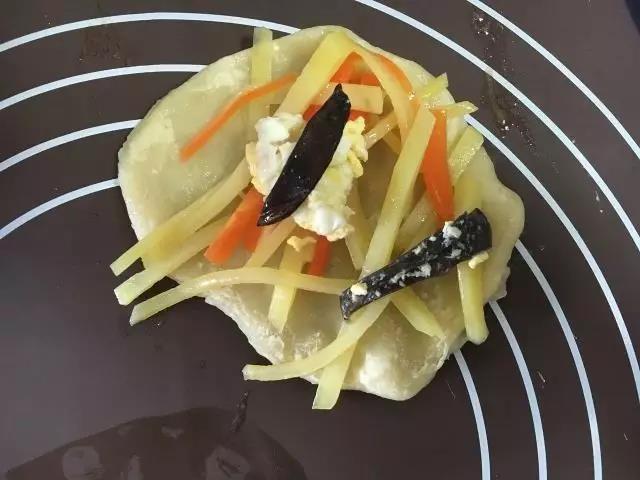 拿出蒸好的面饼，包上炒好的菜，卷起即可。