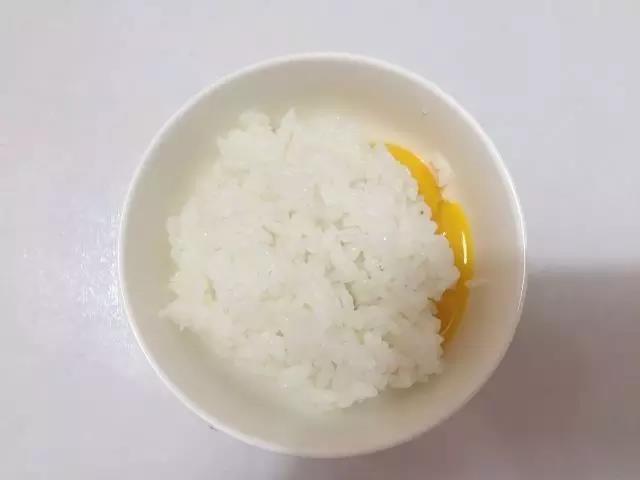 把熟米饭到入蛋黄碗里。