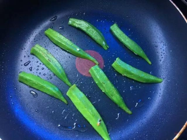 平底锅热油，转小火。放入秋葵条，用小火煎至两面变色。