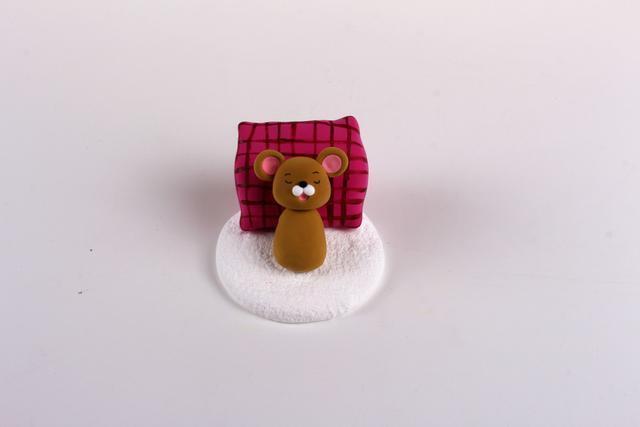 步骤7：用棕色粘土做出小老鼠的身体，和头部粘在一起，然后放在做好的床榻上面。