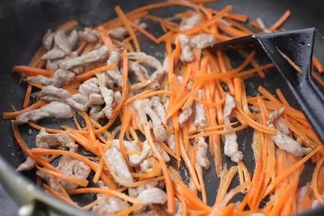 肉丝泛白时加入胡萝卜丝翻炒30秒。