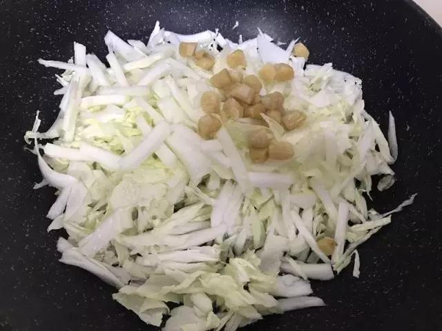 白菜入锅，倒入泡发干贝的水，再把干贝放在白菜表面，盖上锅盖。