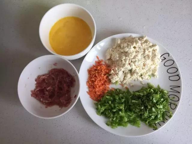 牛肉剁碎用干淀粉腌渍15分钟，蔬菜切碎，豆腐揉碎，鸡蛋打散。