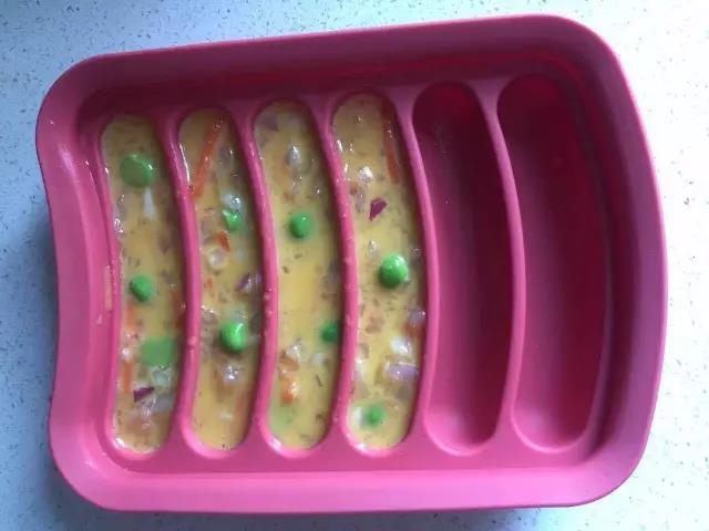 香肠模具用刷子均匀的刷一层油，用勺子把蛋液舀进膜具里，九分满。