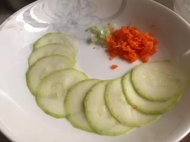 第1步：西葫芦切薄片，胡萝卜、葱切碎，胡萝卜焯熟。