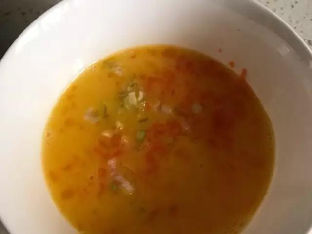 第3步：鸡蛋内加入盐和胡萝卜、葱花，搅拌均匀。