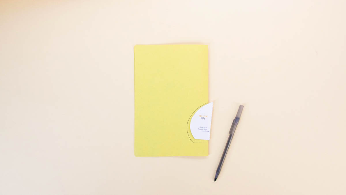 步骤7：接下来，将黄色纸对折。对齐并追踪腹部模板到折叠边缘。