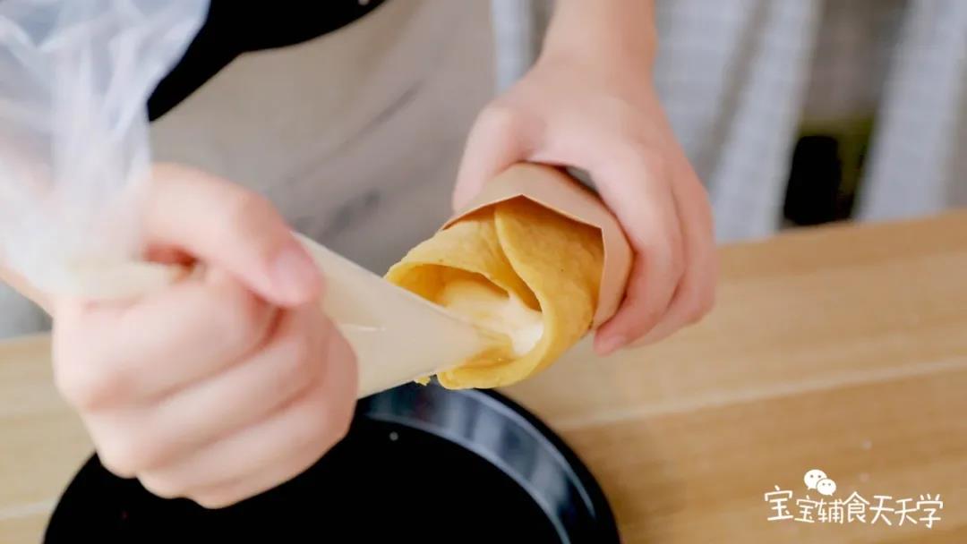 把奶油挤入饼中，放入适量的水果