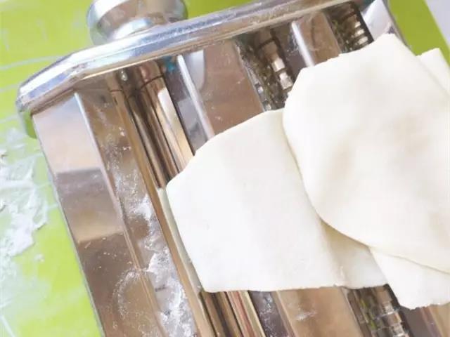 面团放入面条机擀成面片。