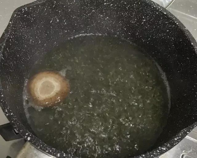 第2步：锅内烧开水，香菇去蒂，焯水2分钟取出，番茄沸水焯一下去皮。