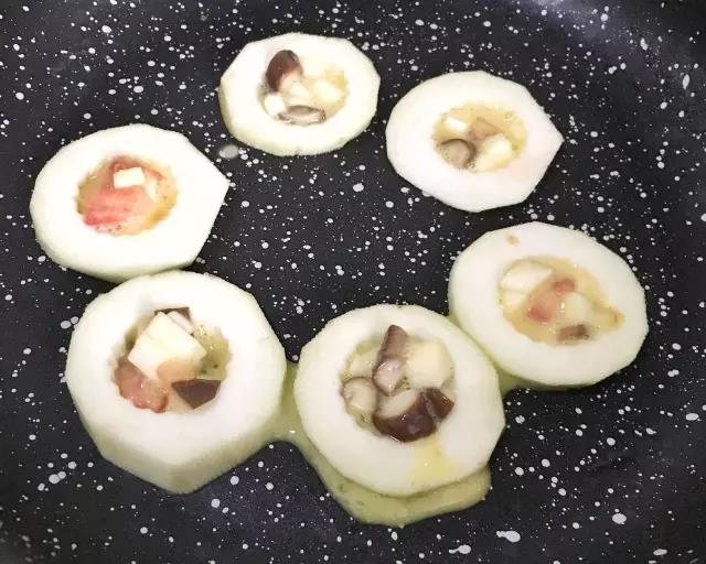 第5步：锅底抹一层油，放入茄子圈，然后用勺子将蛋液倒入，九分满即可。