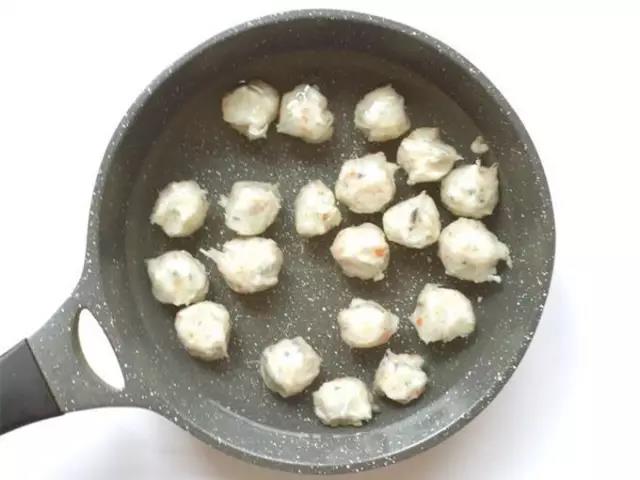 手上沾上凉水，鱼泥从虎口处挤出丸子的形状，冷水下锅。