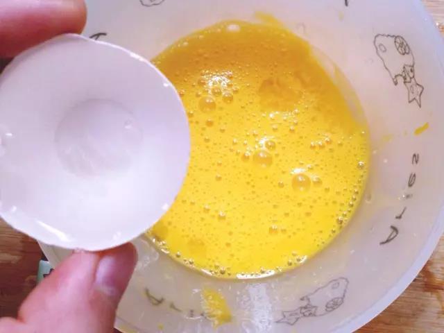 在蛋液中加入两个蛋壳的温水搅拌均匀。 