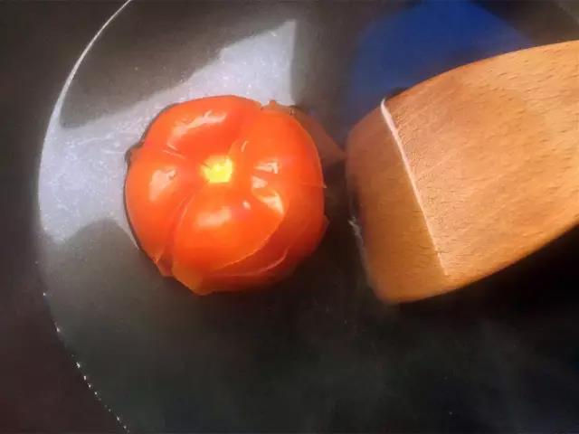 西红柿洗净切十字，水烧开后西红柿下锅烫5分钟去皮