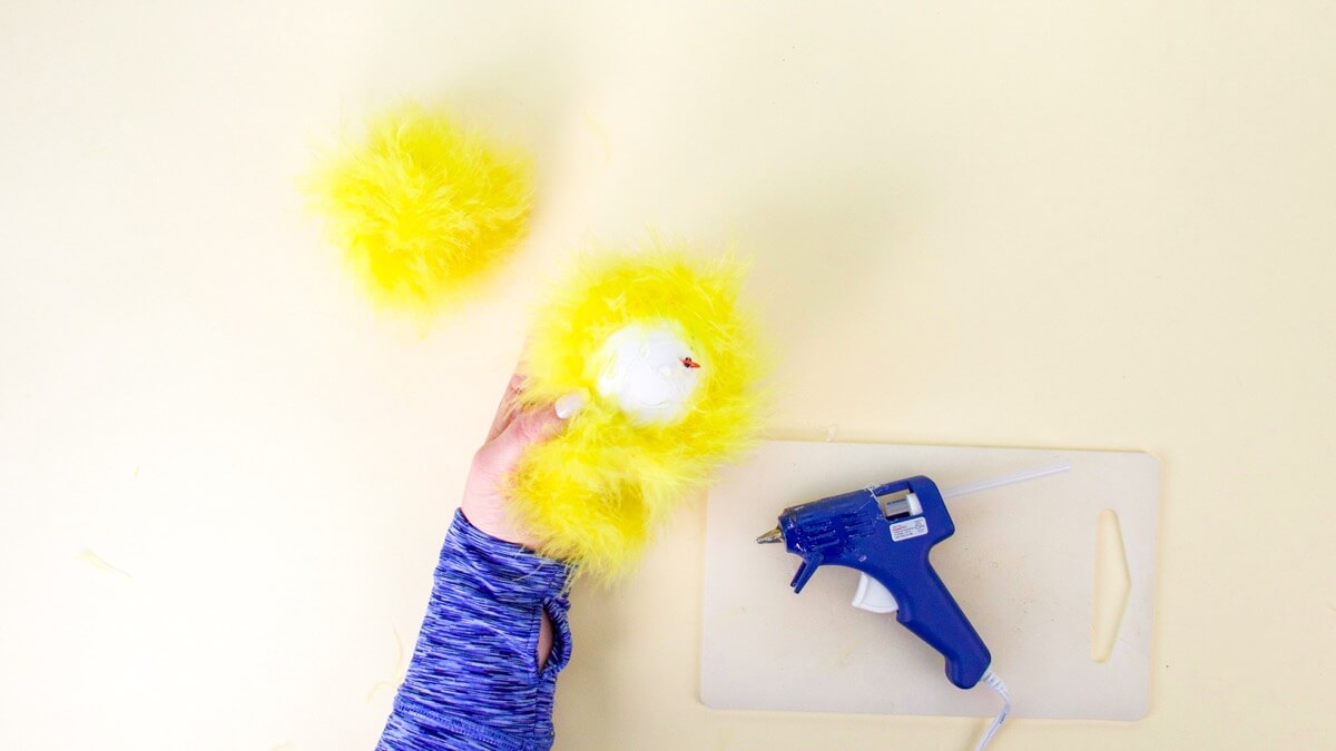 步骤7：接下来，将羽毛蟒蛇粘在泡沫球上。