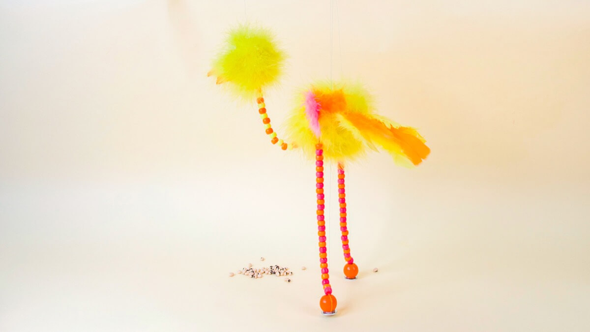 步骤13：接下来，将钓鱼线从脚穿过十字架的两端。将人偶直立起来。