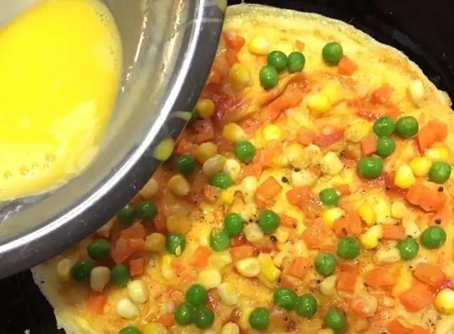 再打散一个鸡蛋，把打散的鸡蛋液倒入配菜上面。