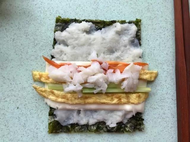 依次放入鸡蛋饼、黄瓜、鳕鱼碎、胡萝卜。