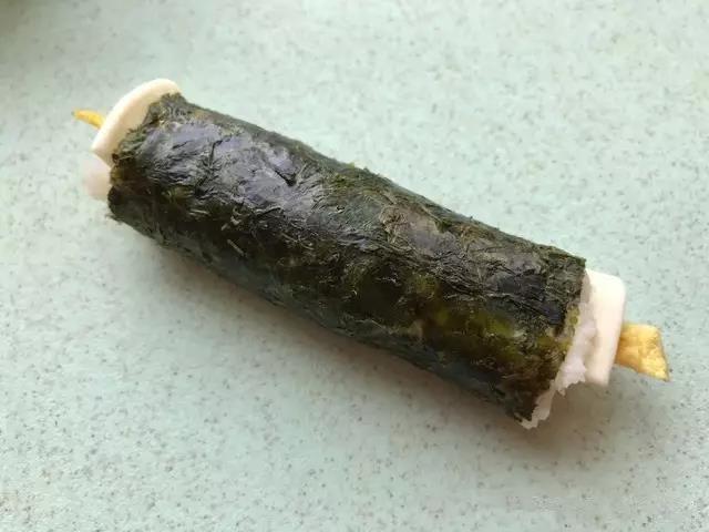 慢慢的卷起来，边缘可以沾点水将海苔粘起来，切块装盘即可。