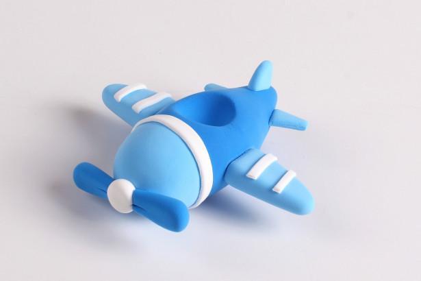 步骤5：按照上图的样子做出飞机的螺旋桨粘在前端，白色粘土切细条粘在飞机翅膀上做装饰。