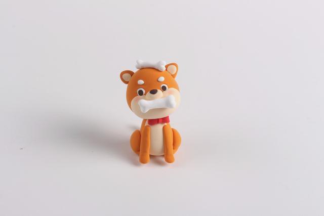 步骤10：把头部和身体粘在一起，再做一根白色骨头粘在柴犬嘴巴上，这样爱吃骨头的小柴犬就做好啦！