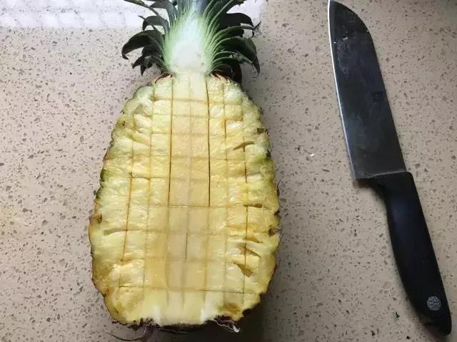 菠萝对半切开，用刀画小方格。