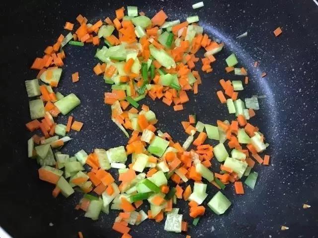 倒入胡萝卜丁和黄瓜丁，大火翻炒2分钟。