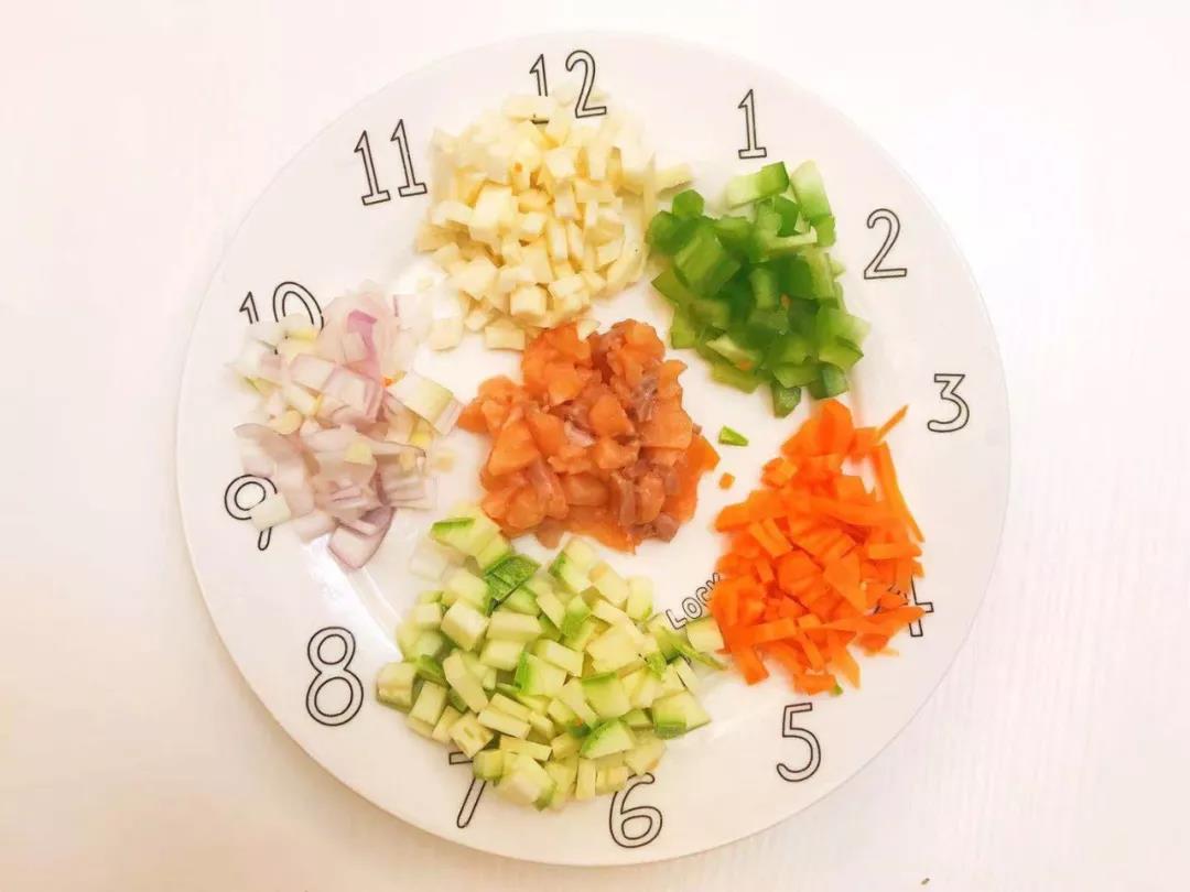 茭白、西葫芦、洋葱、胡萝卜、青椒切碎，三文鱼去鳞去皮切碎。