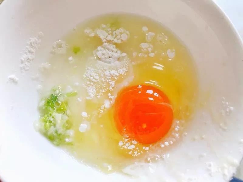 鸡蛋、蒜苗加入面粉中并倒入少量水搅拌成比较稠的面糊，水不要一次倒太多，少量多次添加。