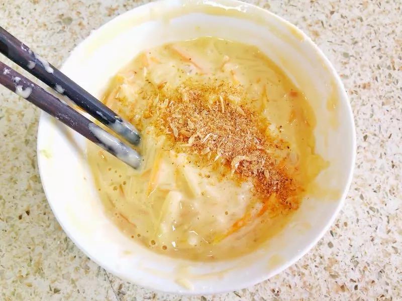 倒入蒸软的土豆胡萝卜丝搅拌均匀，并倒入虾皮粉和油。