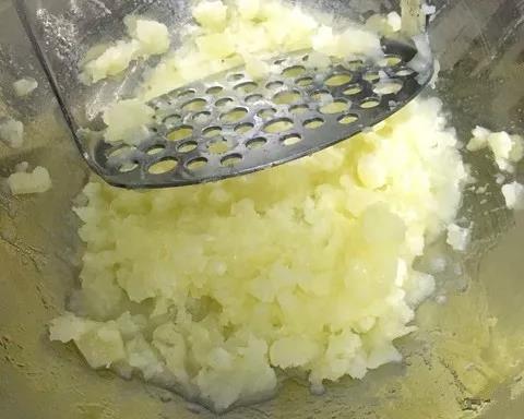 土豆去皮切块上锅蒸熟，用研磨棒按压成泥。
