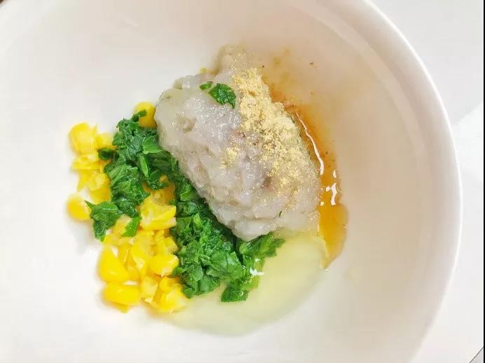 油菜洗净大火焯水，取叶子剁碎，海虾剥壳去除虾线剁成蓉，玉米粒切碎，加入少许蛋液混合均匀，并放入少许姜粉和油。