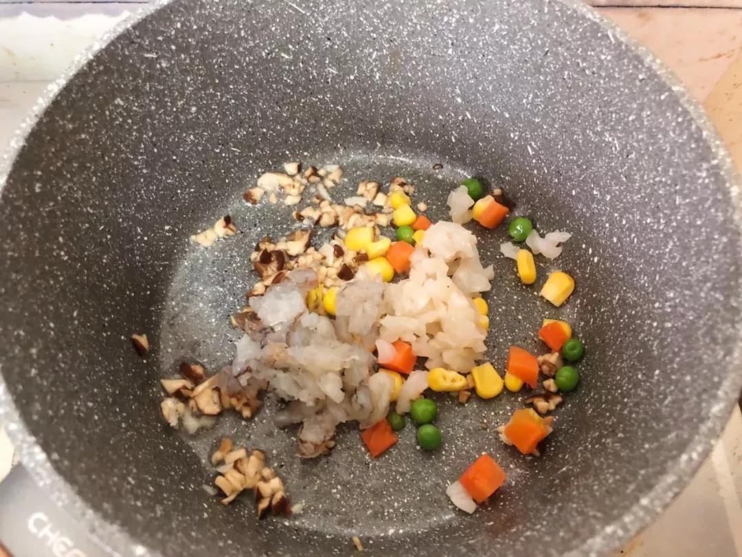 放入虾仁碎、带子碎和玉米豌豆胡萝卜，翻炒均匀。