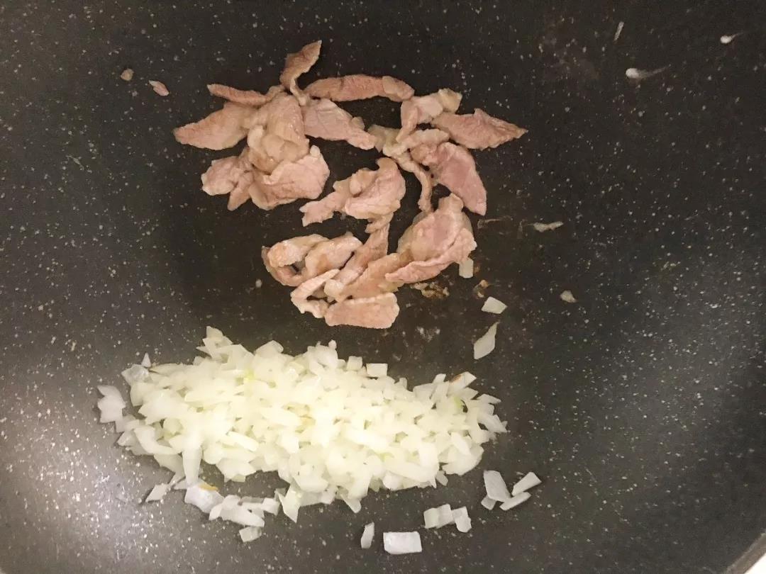 第4步：猪肉丝放入锅中炒至变色，拨至锅边。