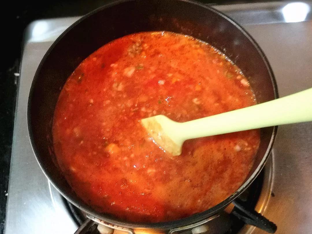 加入碎番茄，并加入开水没过食材。煮开后转小火慢炖，并不断搅拌以免沾锅。