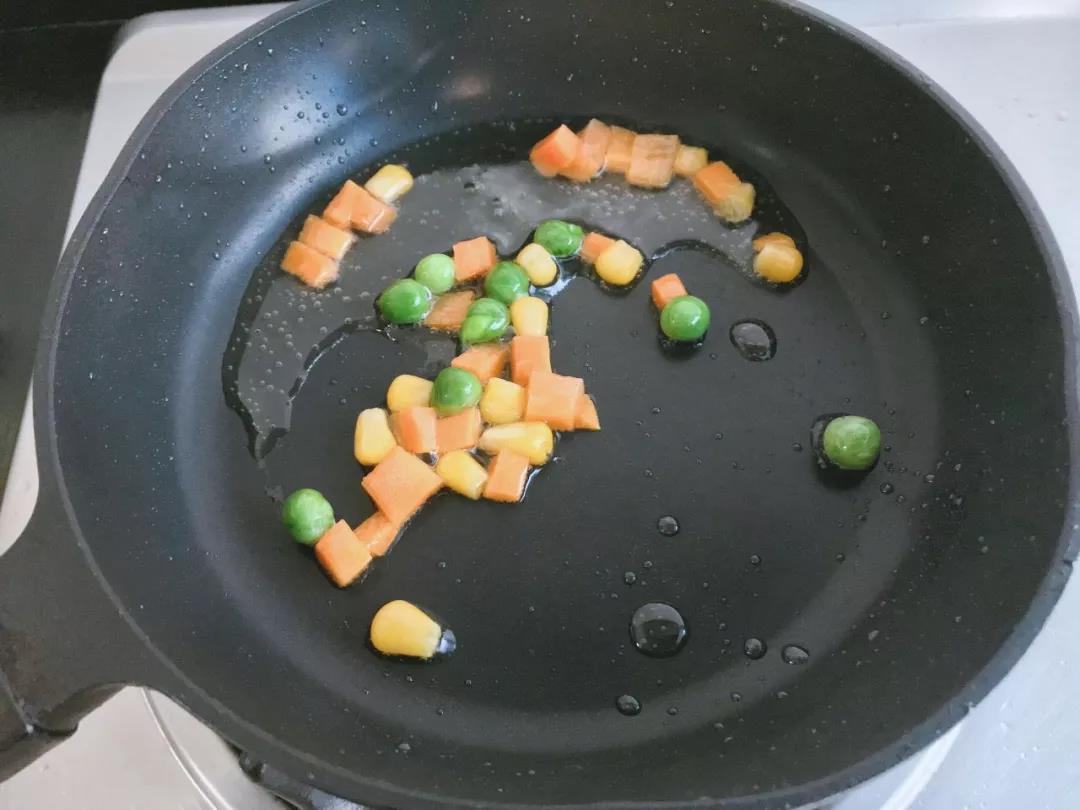 胡萝卜、玉米和豌豆入油锅翻炒，焖至软烂。