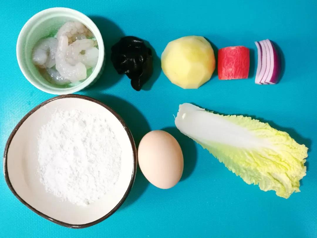 准备好所有食材。洋葱、娃娃菜洗净，土豆、胡萝卜洗净去皮备用。木耳提前泡发。虾仁提前解冻。