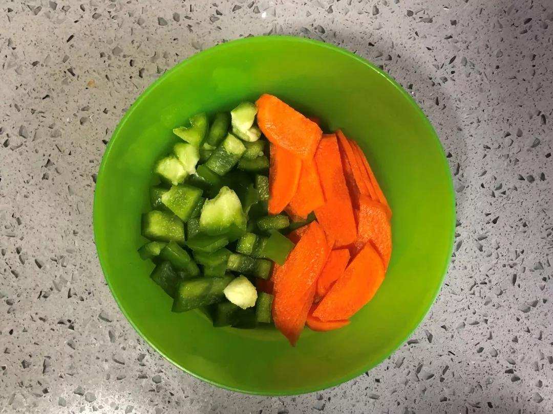青椒洗净切小丁，胡萝卜洗净去皮切片。