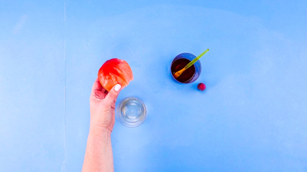 步骤6：将球放在玻璃上作为支撑。用画笔将剩余的食用色素涂在球上。让它干燥过夜。