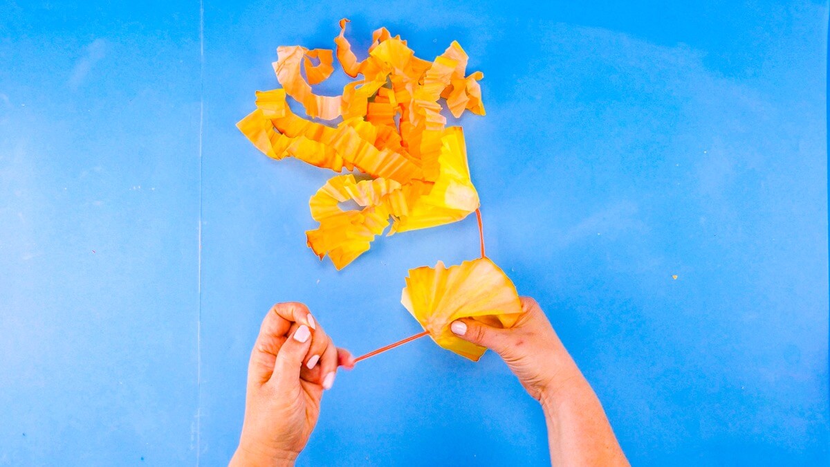 步骤12：接下来，在适合头部下方的两个过滤器上切出小孔。将绳子拉过，通过这些孔将口腔手臂连接在一起。 