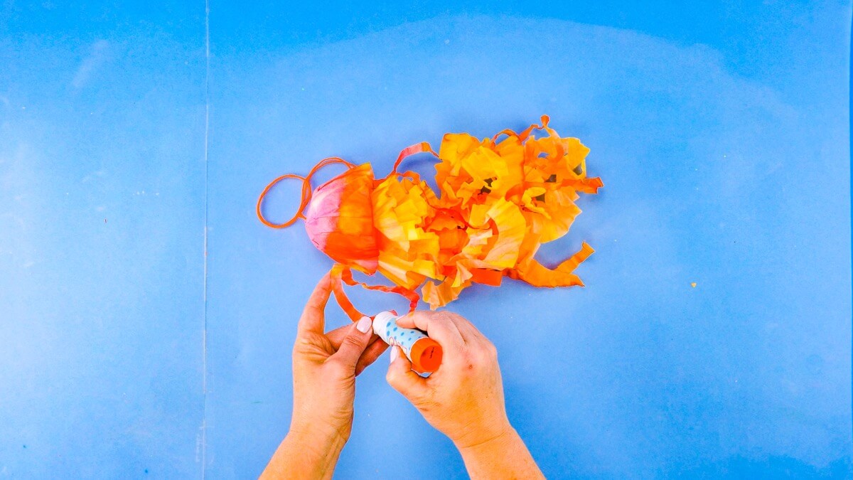 步骤16：用胶棒将触手粘在头部下方。