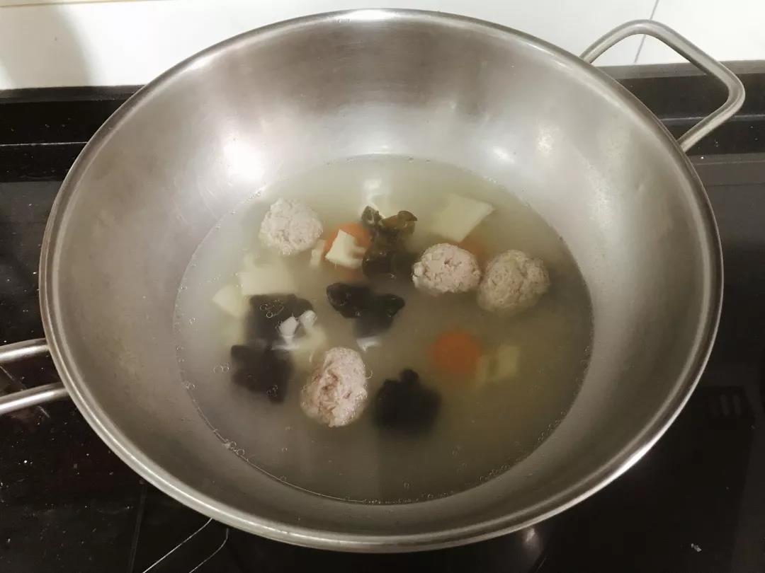 肉泥放入手中，用虎口挤压成肉丸，放入锅中。