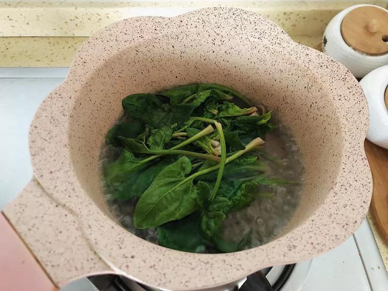第1步：菠菜洗干净，热水锅里捞一遍。然后挤开干水分备用。