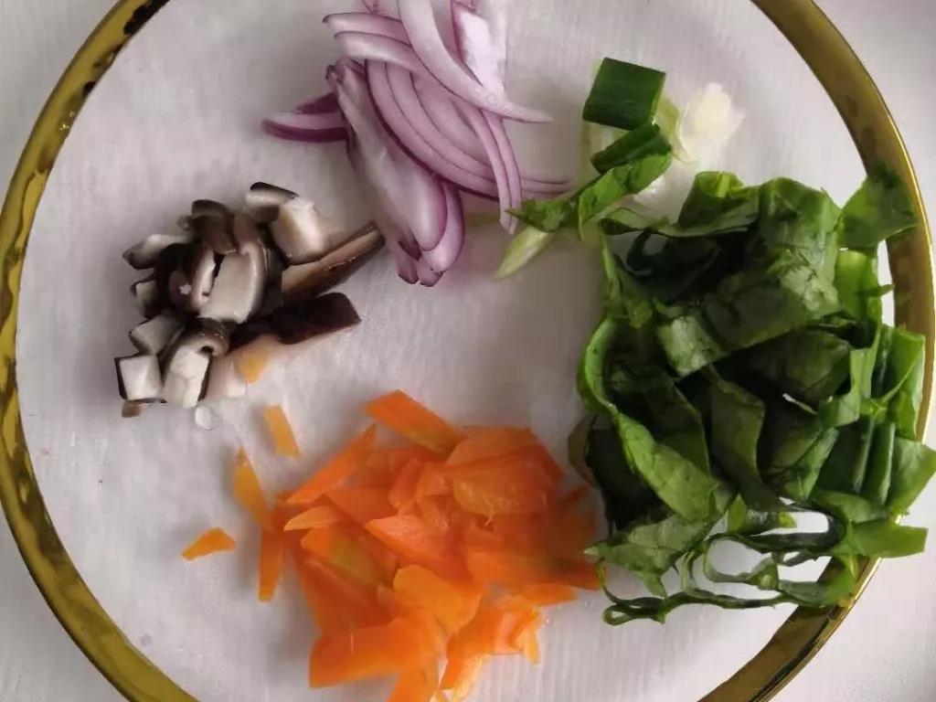 第3步：葱花、洋葱切碎，胡萝卜和香菇焯水后切碎，油麦菜切碎。