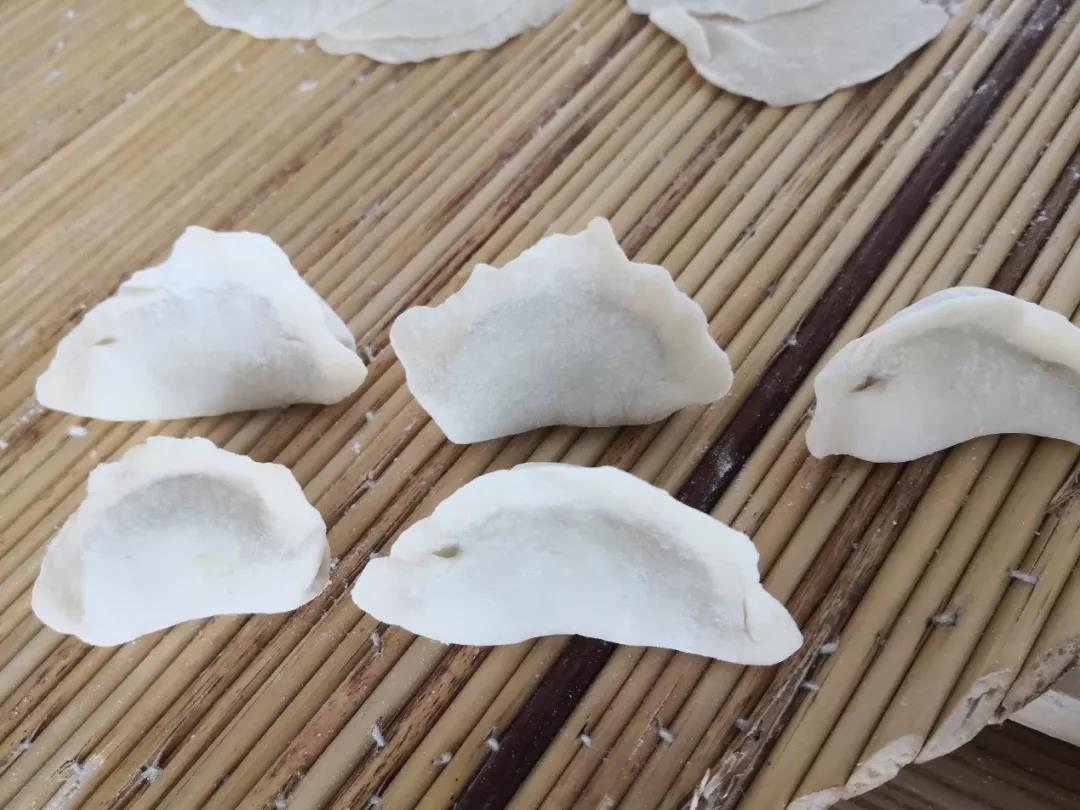 饺子皮中间放馅，对折捏紧。