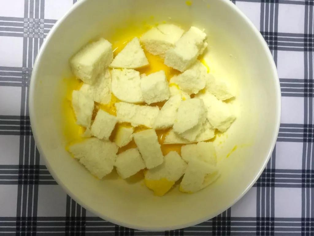 倒入馒头丁，均匀裹上蛋液。